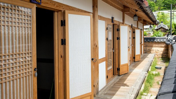 A row of traditional Japanese-style wooden doors with sliding panels, leading to a pathway. - Jiwoodang (Jeonju)