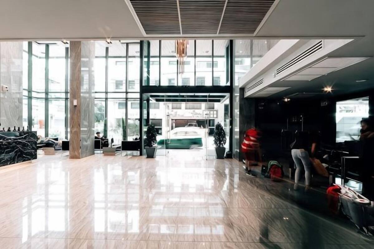 A spacious lobby with a large glass entrance, a reception desk, and a seating area.