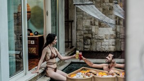 A couple in a pool with a wicker basket containing food and drinks. - Aksari Villa Seminyak by Ini Vie Hospitality (Seminyak)