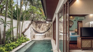 A modern outdoor pool area with a hot tub, surrounded by lush tropical plants and a stone wall. - Aksari Villa Seminyak by Ini Vie Hospitality (Seminyak)