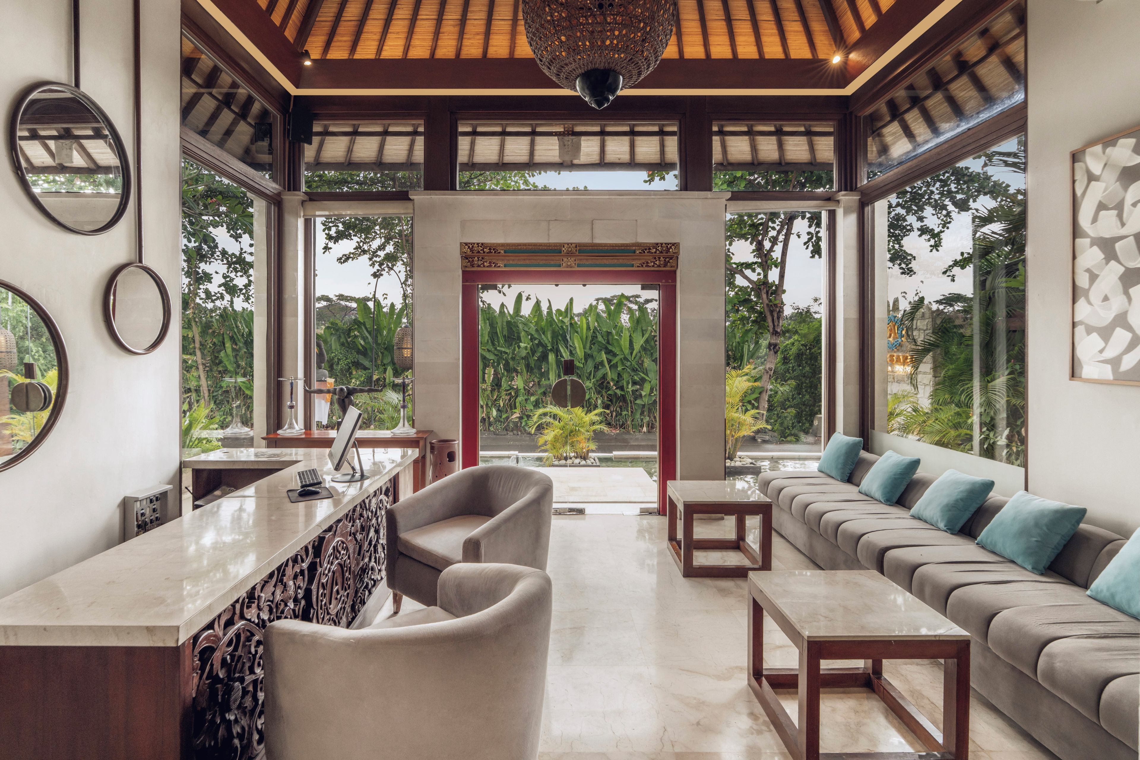 A modern interior with a bar area, seating, and a view of greenery.