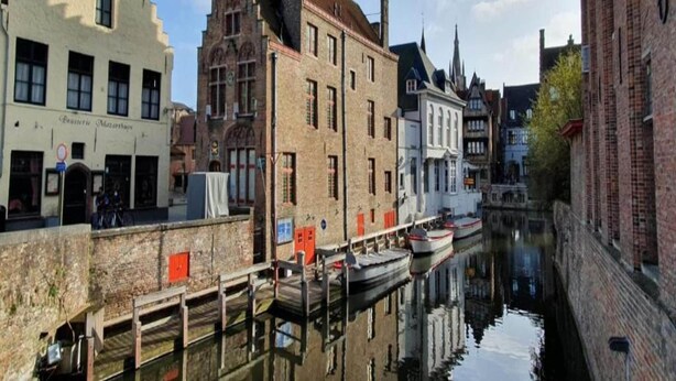 Un canal flanqueado por edificios, entre ellos un edificio blanco con un letrero que dice 