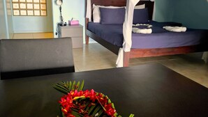 Une chambre à coucher avec un lit à baldaquin, une table de chevet et une petite table de nuit.