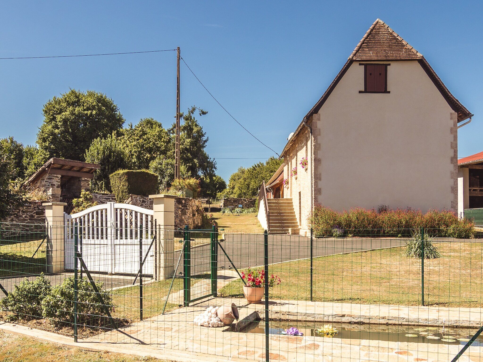 A white building with a triangular roof and a small porch.