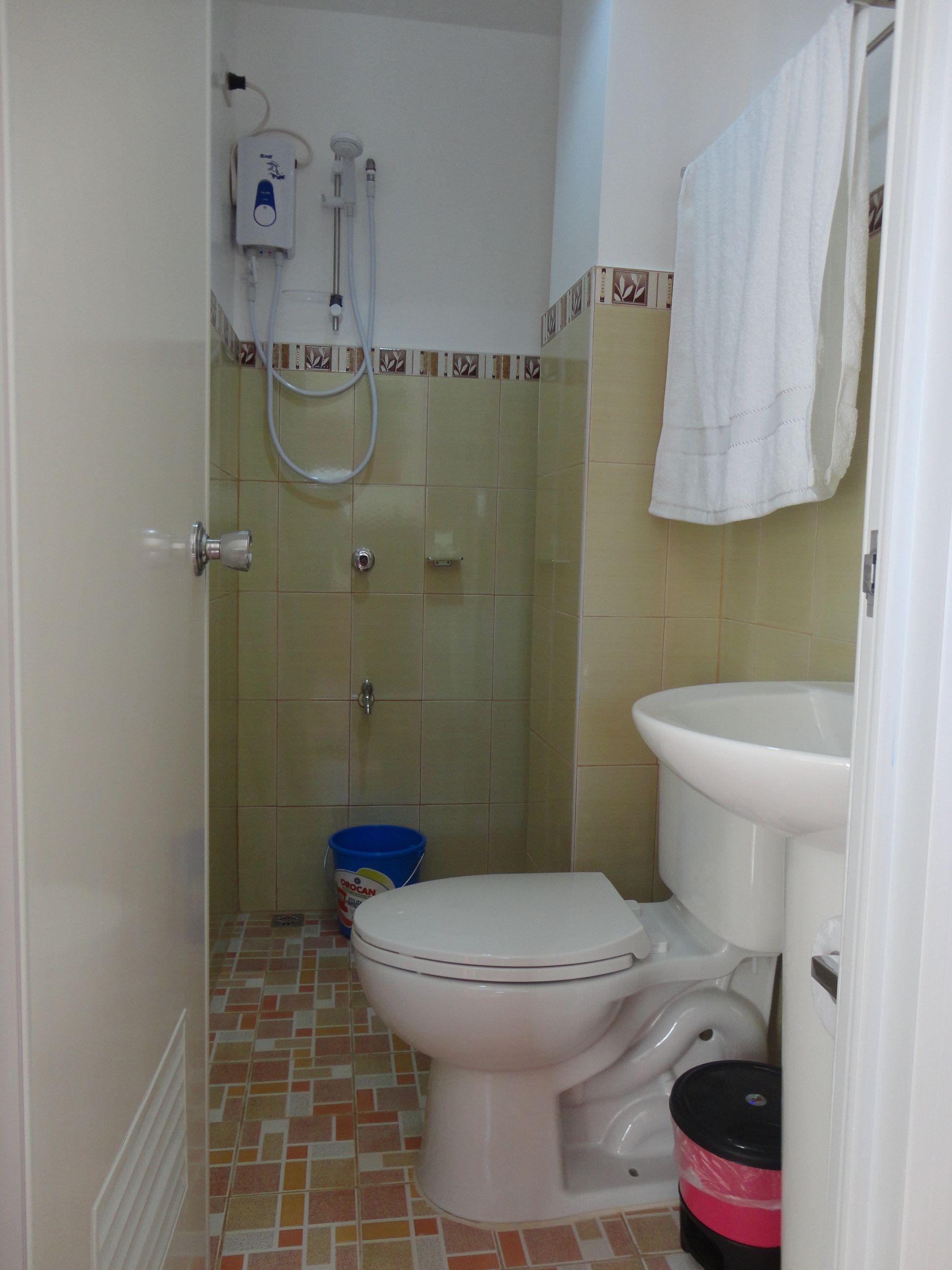 A small bathroom with a toilet, a sink, and a shower.