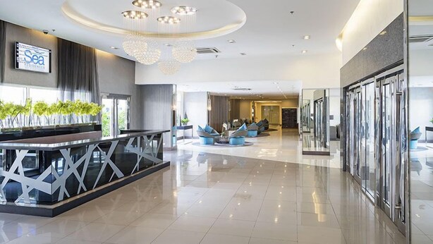 A modern hotel lobby with a reception desk, seating area, and a large chandelier. - Oceanblue Manila Condotel Sea Residences (Pasay)