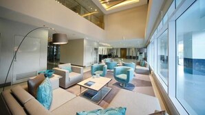 A spacious lobby with high ceilings, modern furniture, and large windows. - Oceanblue Manila Condotel Sea Residences (Pasay)