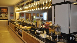 A buffet area with various food items, a coffee station, and a juice bar. - Fortune Park Hotel (Dubai)