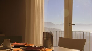 A dining table with plates, cutlery, and a coffee maker on a balcony overlooking a mountainous landscape. - Pekko Country House (Spello)