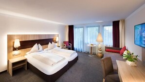Een hotelkamer met twee bedden, een bureau, een stoel, een tafeltje en een televisie.