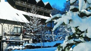 Een gebouw bedekt met sneeuw, met een balkon en een bord waarop 'Hotel' staat.
