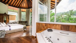 A bedroom with a wooden ceiling, a large window, a bed, a bench, and a bathtub. - Viyana Boutique Hotel (Kandy)