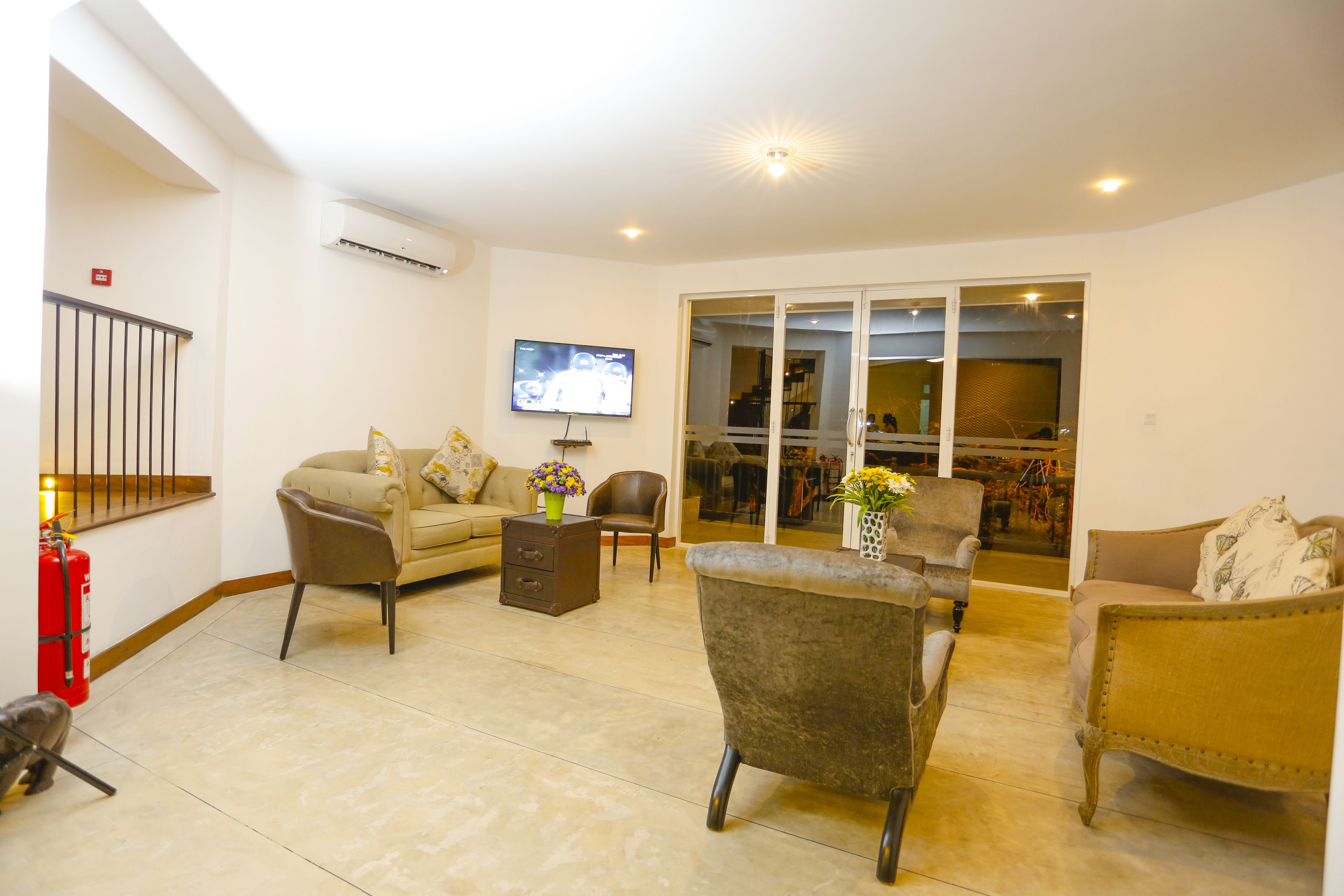 A living room with a sofa, armchairs, a coffee table, and a TV.