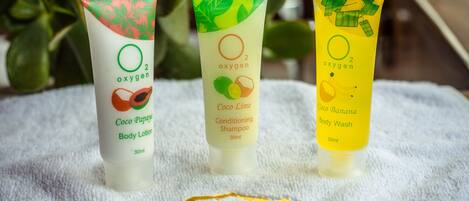 Tres tubos de productos corporales Coco Limón sobre una toalla blanca.