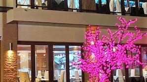 A hotel with a modern design, featuring a two-story structure with large windows and a visible restaurant area on the ground floor. - The Residence Airport & Spa (Bangkok)