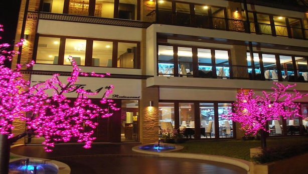 A hotel with a modern design, featuring a restaurant on the ground floor and multiple floors with large windows. - The Residence Airport & Spa (Bangkok)