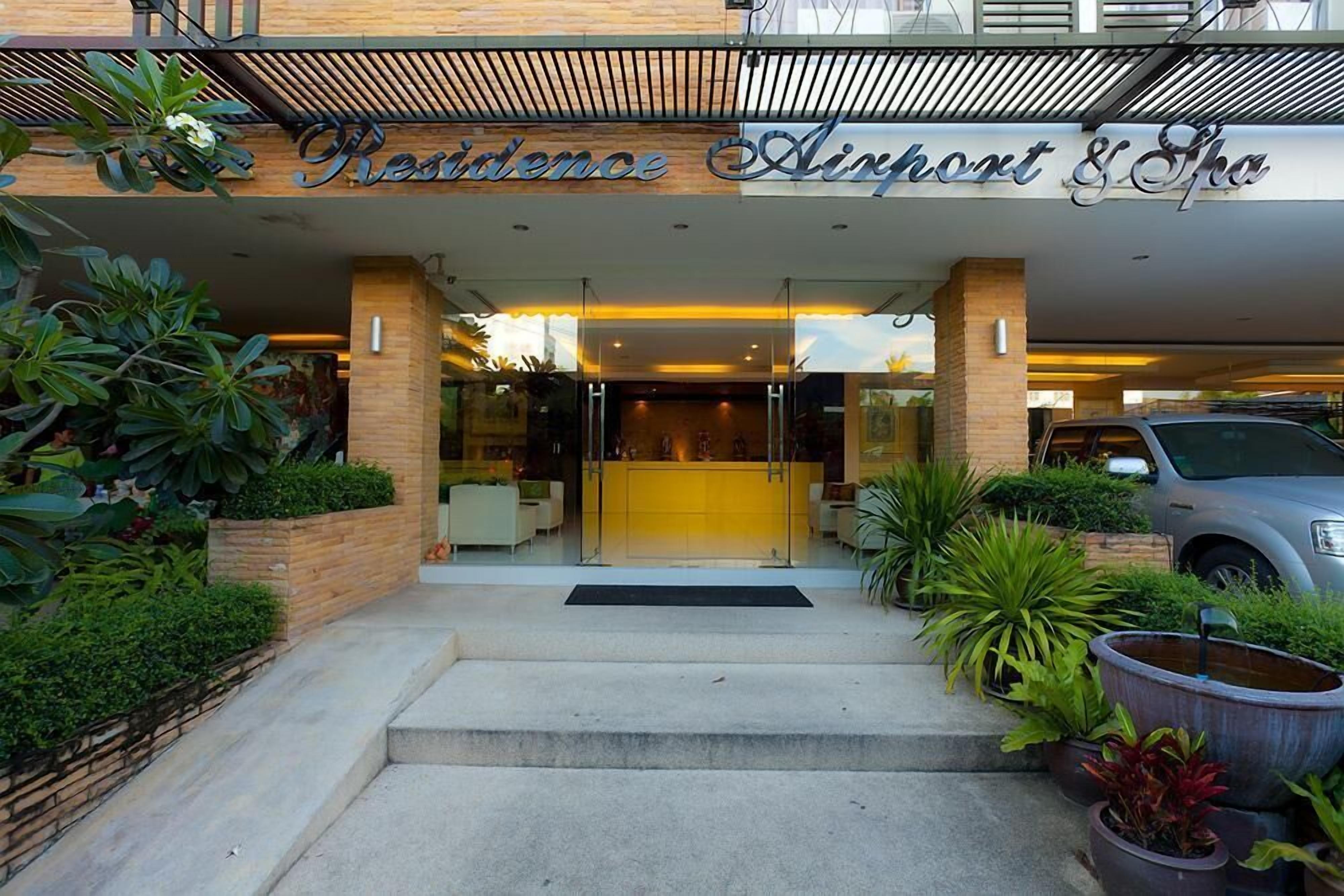 La entrada de Residence Airport & Spa presenta un diseño moderno, con un puerta de vidrio y escalones que conducen a la entrada.