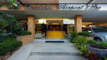 La entrada de Residence Airport & Spa presenta un diseño moderno, con un puerta de vidrio y escalones que conducen a la entrada.