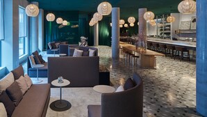 A modern lounge area with sofas, chairs, a bar, and decorative lighting. - Zander K Hotel (Bergen)