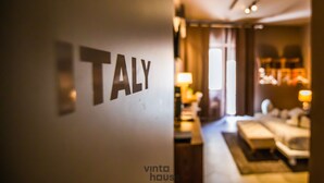 Een hotelinterieur met een bord waarop 'ITALY' staat, en een gezellige zithoek met een bank en een salontafel.