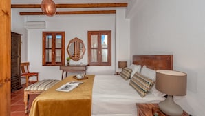 A bedroom with a bed, bedside table, lamp, and wooden furniture. - Casa Sabbionara (Chania)