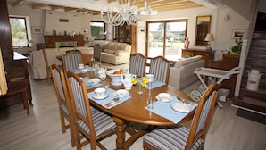 Comedor con una mesa de madera dispuesta para cuatro personas, rodeado de sillas a rayas.