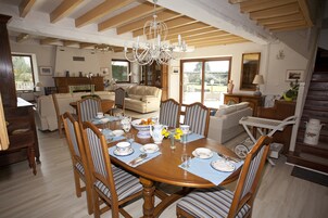 Comedor con una mesa de madera dispuesta para cuatro personas, rodeado de sillas a rayas.