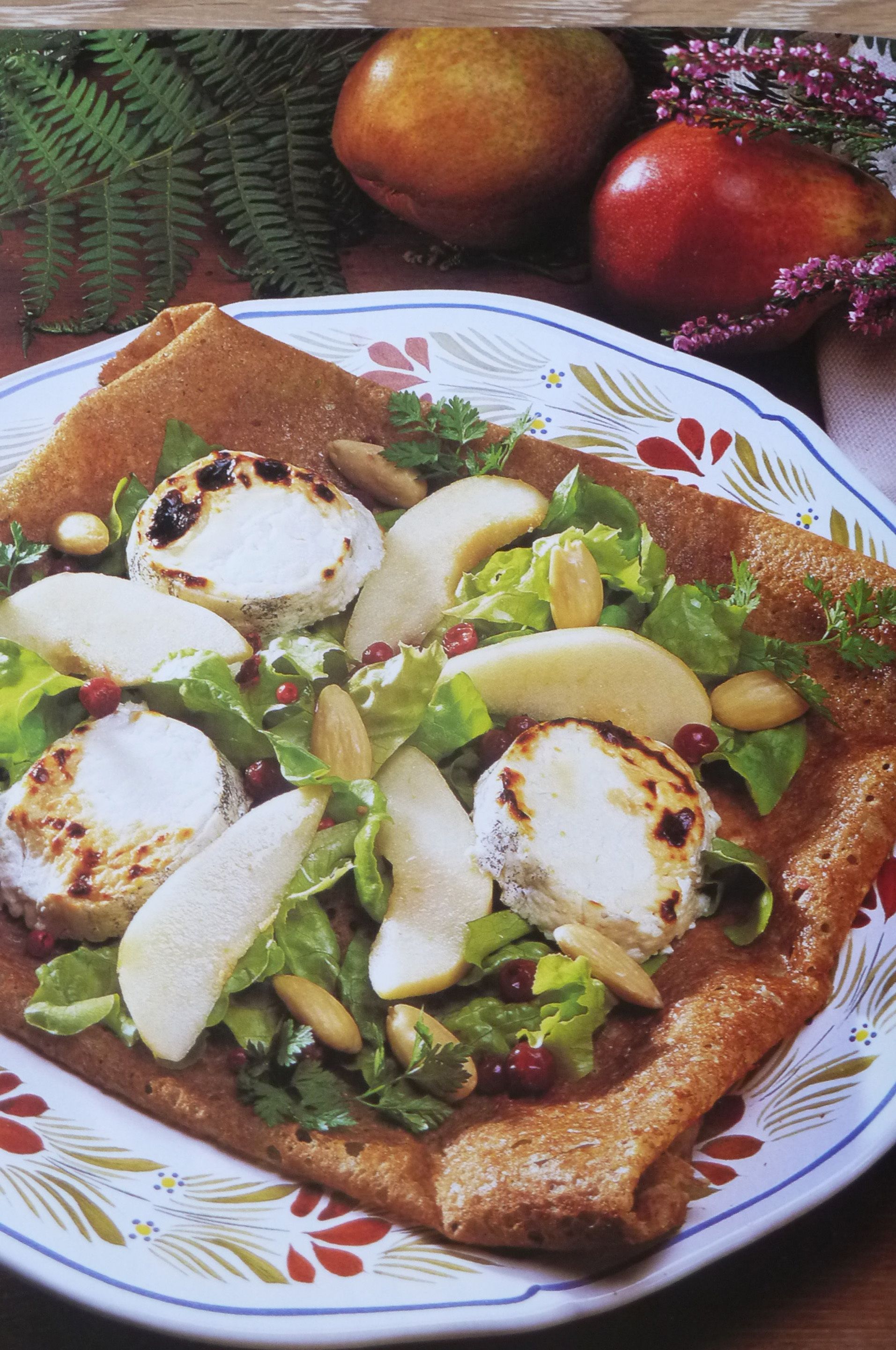 A plate of food with cheese, nuts, and greens.