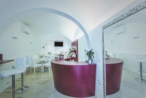 Experience the grandeur of this spacious room, featuring a stunning semi-circular archway and elegant dining area with a round table and comfortable seating.