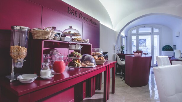 A breakfast buffet area with a red counter, various food items, and a sign reading "B&B Porta Nuova". - B&B Portanuova (Vasto)