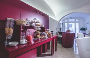 A breakfast buffet area with a red counter, various food items, and a sign reading "B&B Porta Nuova". - B&B Portanuova (Vasto)
