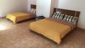 A hotel room with two beds, each with a brown bedspread, a nightstand with a phone, and a wall-mounted TV. - CK Residence (Hat Yai)