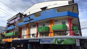 A multi-story building with colorful facades, a signboard advertising 4G services, and a visible satellite dish. - CK Residence (Hat Yai)
