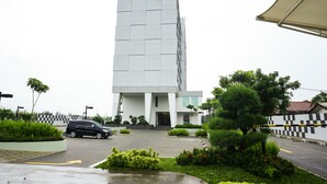 A modern building with a checkered wall and a car parked in front. - GTV Hotel & Service Apartment (Cikarang)