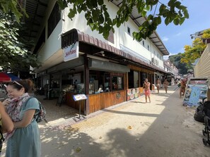 A street with a restaurant named "Twin Palms" and a sign for a taxi boat service. - Twin Palms Hostel Phi Phi (Ko Phi Phi)