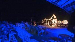 A beachside event with a stage and chairs arranged for an audience. - Twin Palms Hostel Phi Phi (Ko Phi Phi)