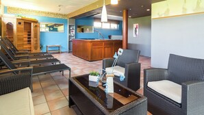 A hotel lobby with a reception desk, seating area with chairs and a sofa, a massage room, and a small reception counter. - Group Escape in Mellier (Mellier)