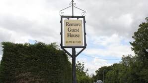 A sign for 'Remarc Guest House' with a contact number. - Remarc House Stansted (Bishop's Stortford)