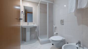 Un baño moderno con ducha, inodoro, lavamanos y bidé.