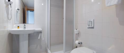 A modern bathroom with a shower, toilet, sink, and hairdryer.