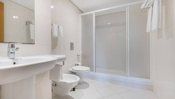 A modern bathroom with a sink, toilet, and shower area.