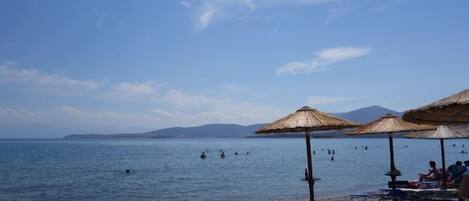 En la playa, sillas reclinables de playa, sombrillas, bar en la playa