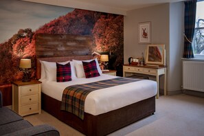 A bedroom with a large bed, a nightstand, a dresser, and a window with curtains. - Crown Inn at Pooley Bridge (Penrith)