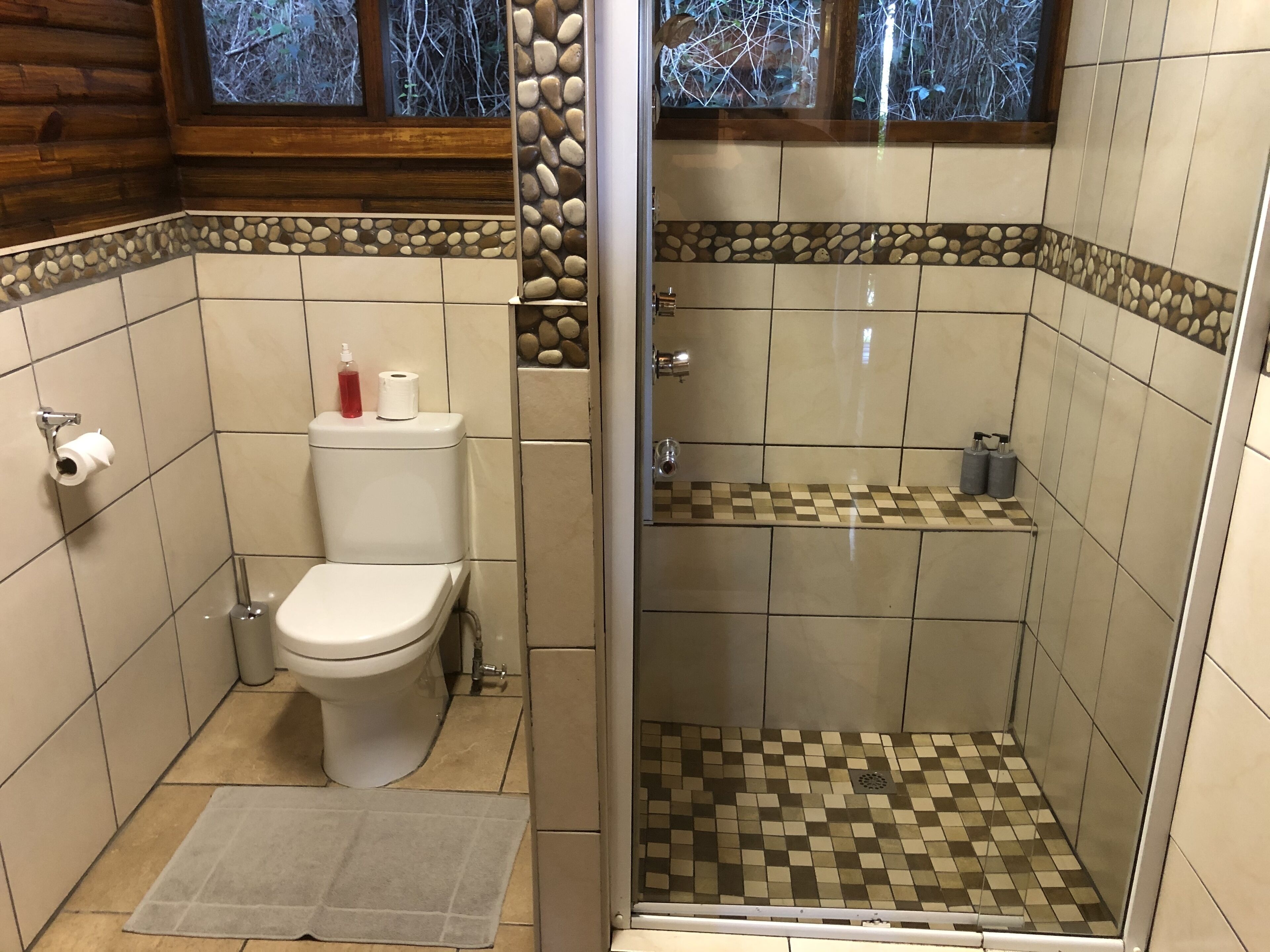 A bathroom with a toilet, a shower, and a sink.