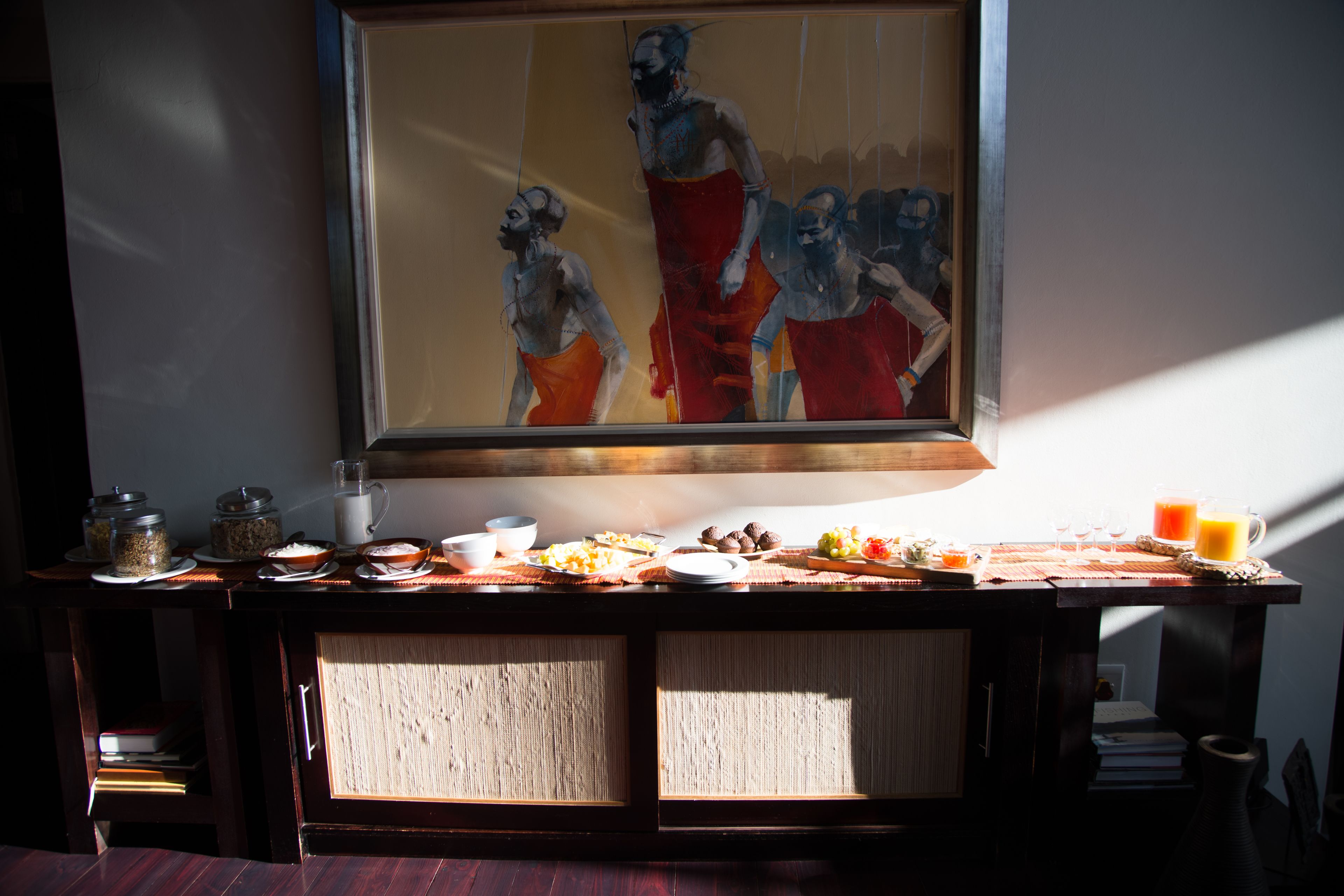 Un buffet de petit-déjeuner proposant divers plats et une peinture accrochée au-dessus.