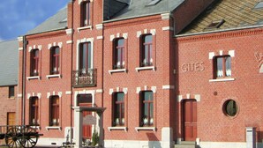 A red brick building with multiple windows and a balcony.