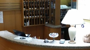 Una recepción con un mostrador de madera, una lámpara blanca y una escultura de pez.