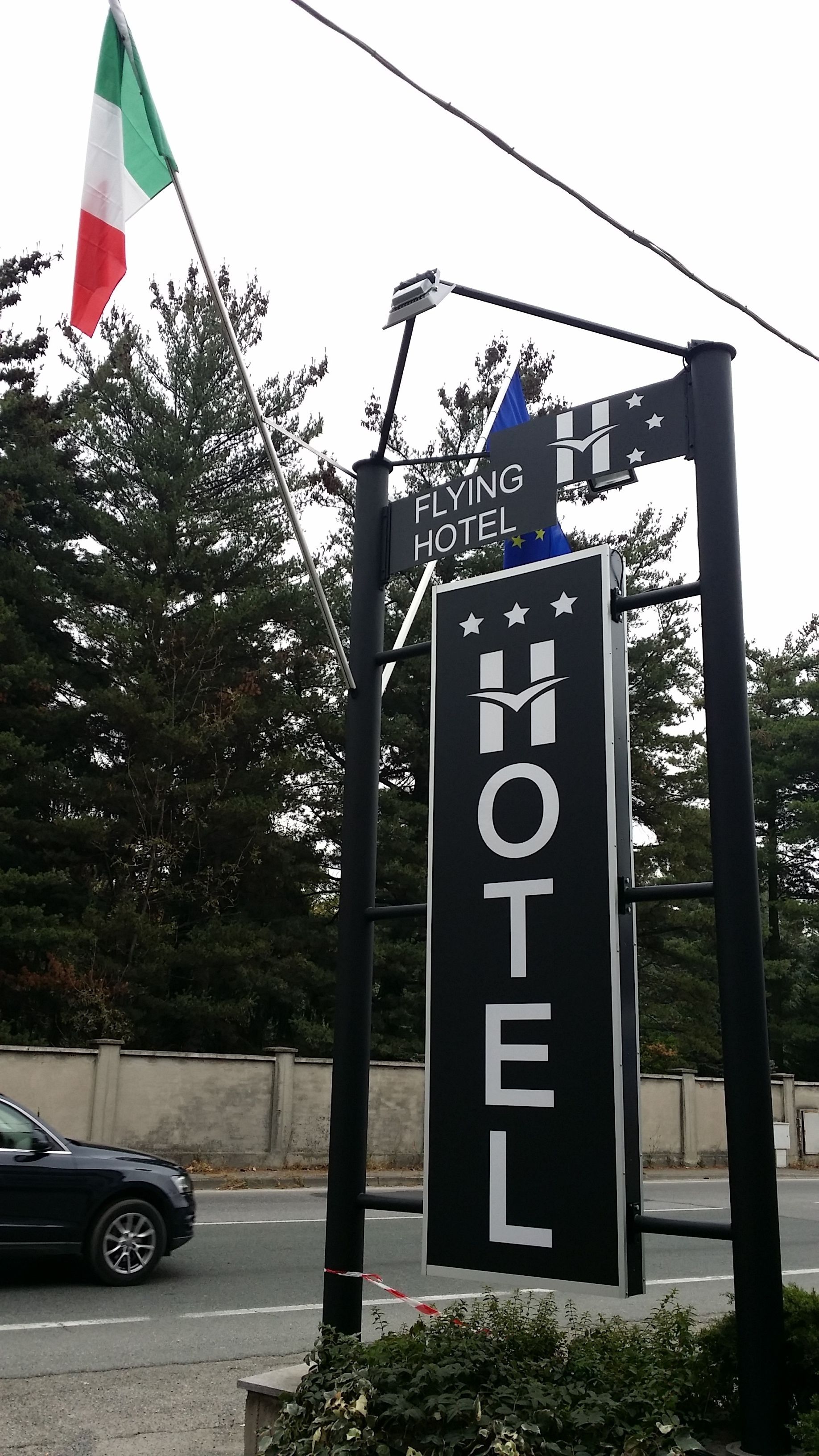 Een hotelschild met een wimpelstok en een vlag.