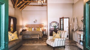 A cozy bedroom with a bed, a chair, a dresser, and a mirror. - Onse Rus Guest House (Prince Albert)