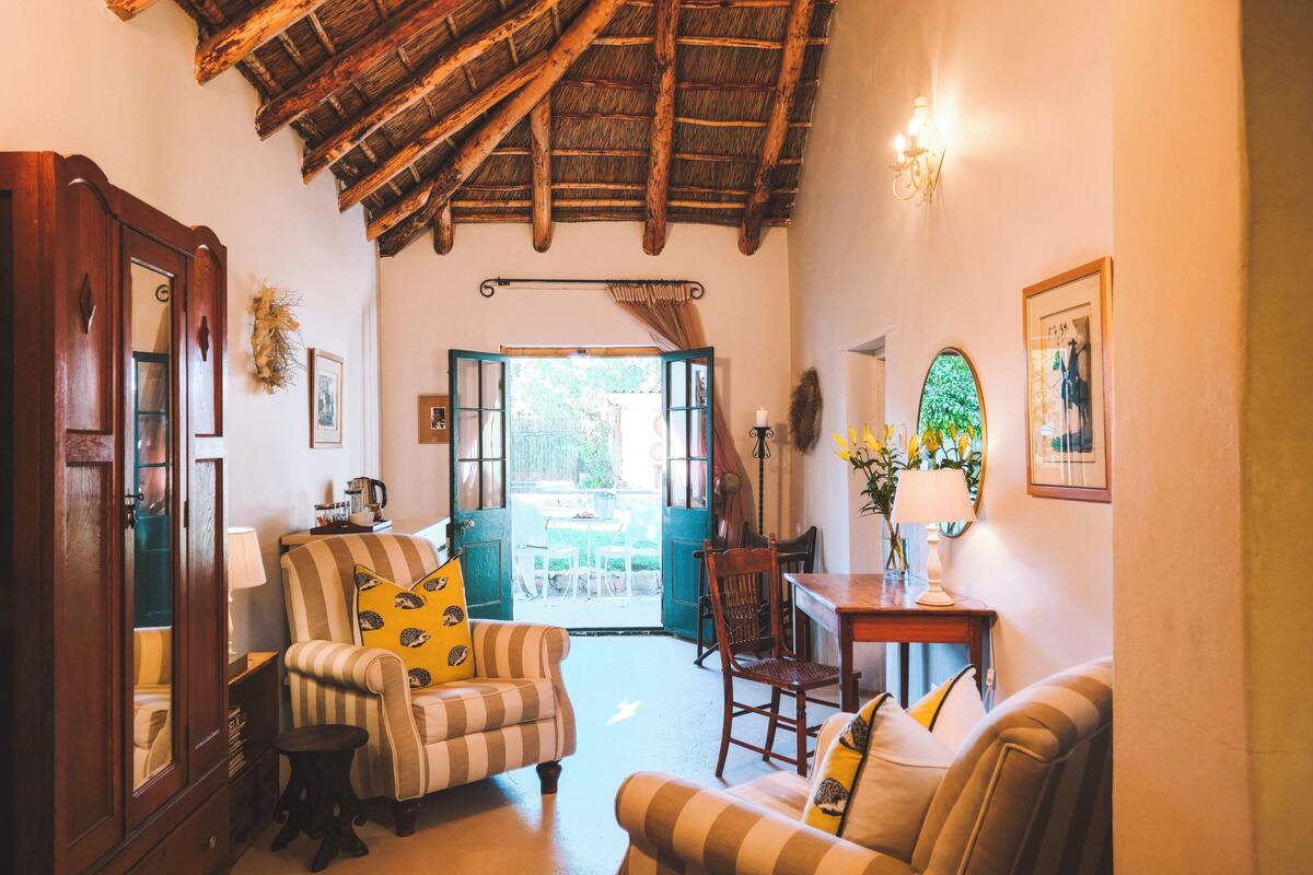 A cozy room with a wooden ceiling, a dining area with a table and chairs, and a view of the outdoors.